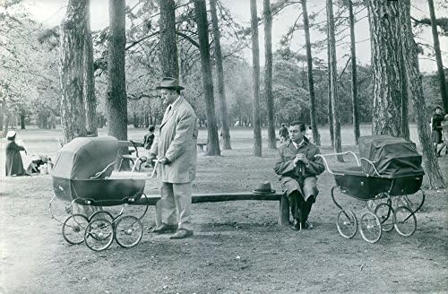Гроздобер фотографија на FRAN231; OIS P233; Риер седи на клупата на паркот и гледа на човек што турка количка.